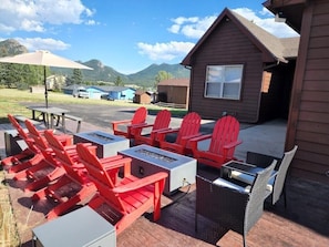 2 x 4 ft Fire tables surrounded by 8 Adirondack chairs. picnic table w/ shade