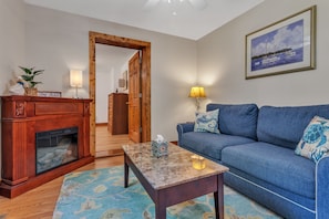 Living room with fireplace and memory foam sofa bed.