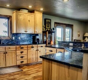 Large spacious kitchen with granite countertops and island with seating for 6 