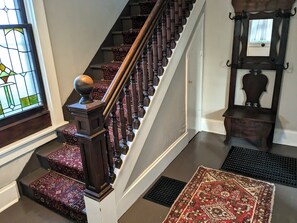 Staircase to 2nd floor with stained glass window