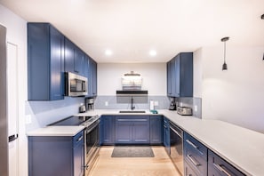 The gourmet kitchen has new stainless steel appliances, hardwood flooring and gorgeous hardwood cabinetry