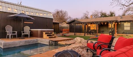 Backyard built for entertaining! Wading pool, hot tub, fire pit, cornhole, dual grill, outdoor dining table, string lights, and more!
