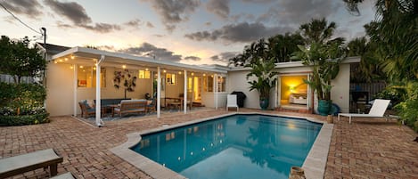 Indulge in a tropical retreat as you step onto the private pool deck, complete with sun loungers, an outdoor dining area, and a relaxation zone. The covered patio boasts a grand outdoor mirror and a captivating orchid wall display, adding to the allure.
