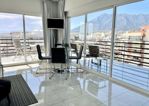 Big glass windows with open views towards the mountain, old town and beach