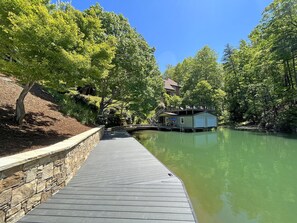 A long dock runs along the landscaped slope up to the patio/fireplace.  This is a view from the dock back toward the boathouse
