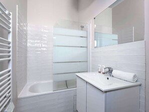 Bathroom includes a bath that can also be used as a shower, towels, and a starter set of shampoo and soap for you.