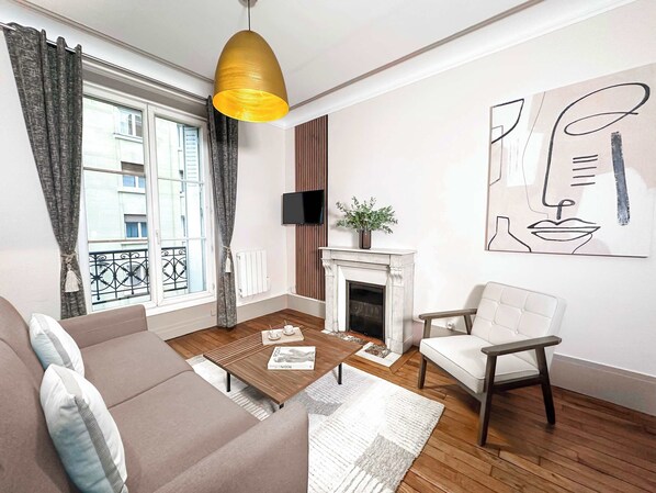 The living room features a double sofa bed, HD flat-screen TV, and free high-speed Wi-Fi.