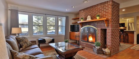 The spacious cozy living room with wood burning fireplace.