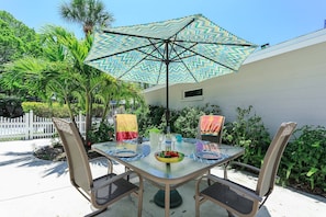 Outdoor open patio with dining for 4 under some shade