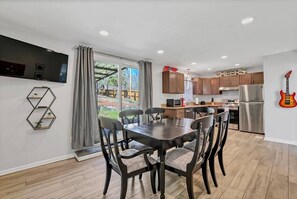 Dining area open to the kitchen and wall mount TV