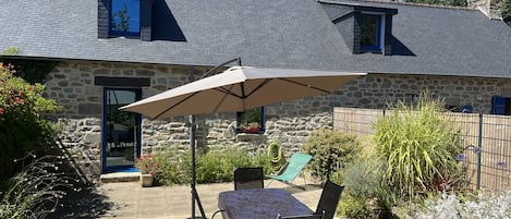 Vue de la maison et de la terrasse depuis le jardin.
