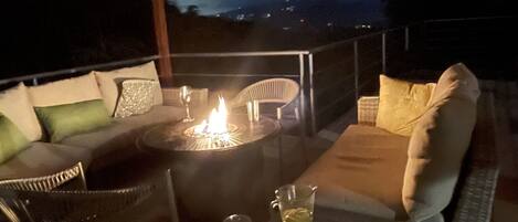 Gas fire table is great place to chill. City lights in mountains in distance. 