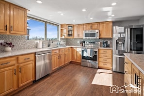 The kitchen features updated stainless steel appliances and equipped with cooking essentials for your next meal.