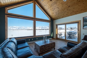The first floor living room features floor-to-ceiling windows with mountain view