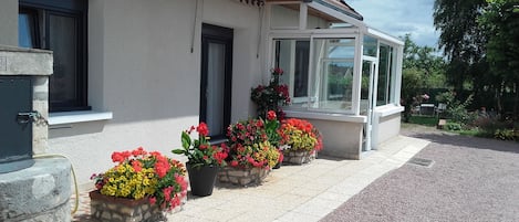 Façade Sud, terrasse fleurie, véranda et aperçu du Parc