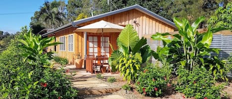 Front of studio from the garden, with outdoor table and chairs.