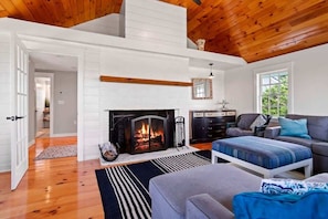 Cozy fireplace with warm pine cathedral ceiling