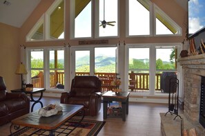 Comfortable and spacious seating surrounded around the wood burning fireplace with the beautiful mountains in the background.