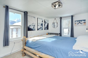 This bedroom provides a serene atmosphere with a mountain view, complementing decor and a comfortable king-sized bed. 