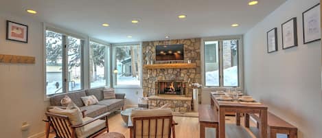 Comfortable, stylish living room with gas fireplace and dining table