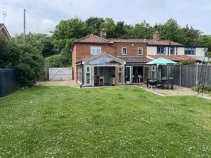 The large enclosed sunny garden has patio furniture and a BBQ.