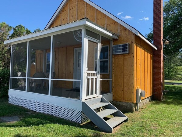 Screened porch w/ chairs that is overlooking the outdoor pool!