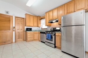 fully stocked kitchen with utensils, cookware and some basic spices