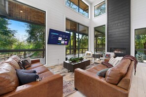 The open concept space offers plenty of seating around the Smart TV. The floor to ceiling windows allow plenty of natural light.
