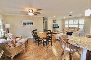 The gorgeous view from the kitchen; center of the room dining, barstool counter seating & sitting area on left.