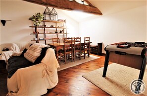 Gîte "Le Havre des Gonons" à Cenves - Haut Beaujolais - Rhône : la mezzanine avec coin-salon, coin repas et baby foot.