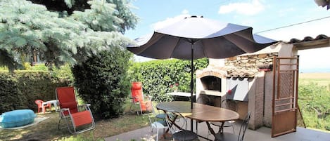 Gßte "La Colline Fleurie" à Rontalon, dans le Lyonnais - RhÎne : la terrasse et portillon d'accÚs au pré avec portique en contrebas.
