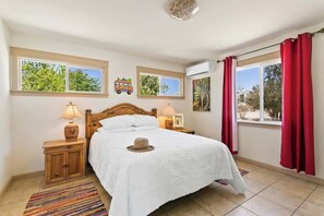 Primary bedroom features queen bed, hand carved Mexican furniture, bedside reading lamps, pool and mountain view.