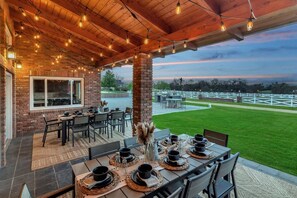 [Resort Property] Covered patio with seating for 16 near gas grill and kitchen area overlooking beautiful views
