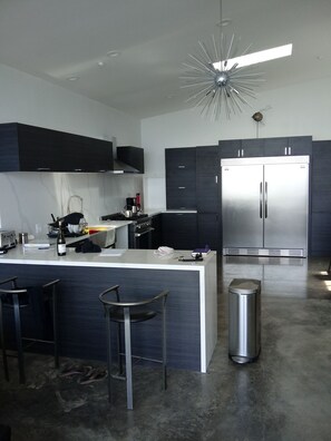 Modern kitchen with built in fridge, dishwasher, gas range and quartz counters