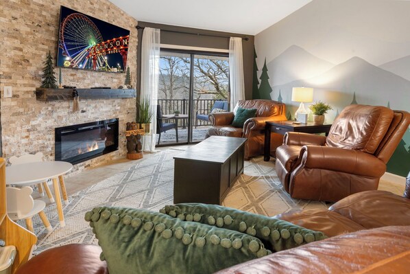 Living room with plush leather furniture, electric fireplace & kids corner