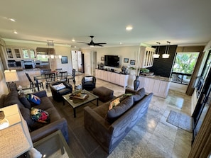 Full view across great room to entrance with kitchen top left, wet bar far right