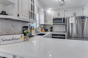 Completely renovated Kitchen w/ gorgeous tile backsplash, new pull-down faucet and granite undermount sink!  Enjoy cooking in the brand new 30" oven and electric glass cooktop!