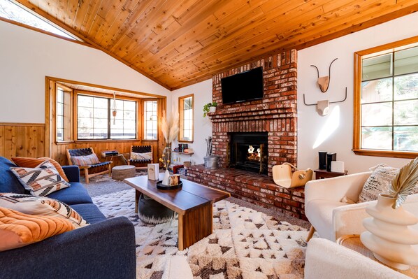 Living room with fireplace, tons of windows and natural light.