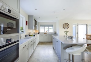 All Views, Burton Bradstock: The spacious and well-equipped kitchen with island, wine fridge and bar stools