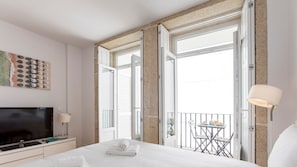 Clean and bright bedroom area with TV. #downtown #porto #airbnb