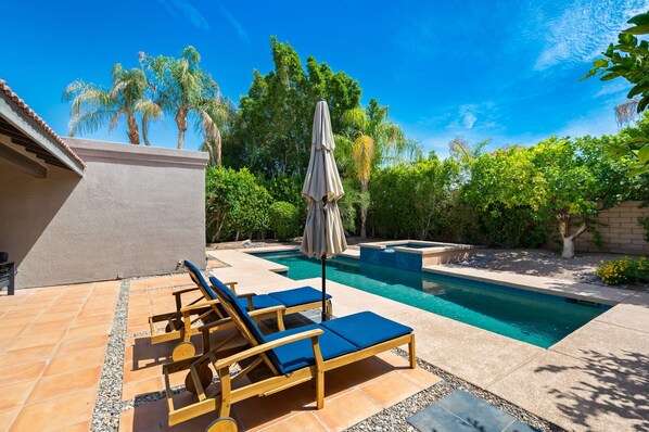 Pool and spa area with lounge chairs. 