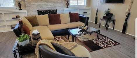 Spacious den with comfy sectional, swivel chair and 65" smart TV