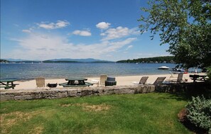 Beach is stocked with tables, chairs, BBQ pits and kids toys. 