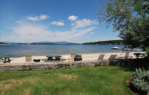 Beach is stocked with tables, chairs, BBQ pits and kids toys.