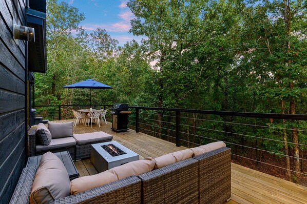 Outdoor Terrace: Savor evenings by the fire table amidst stunning wooded views!