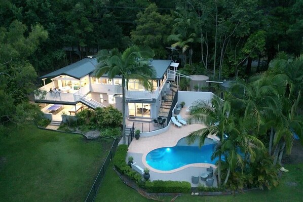 Aerial of resort style home with spa and heated pool