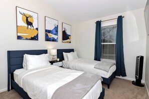 Bedroom 2: Twin XL beds dressed in comfy white linens facing a Smart TV