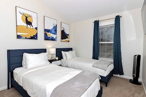 Bedroom 2: Twin XL beds dressed in comfy white linens facing a Smart TV