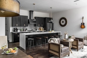 Fully equipped kitchen with stainless steel appliances, large island and bar seating.