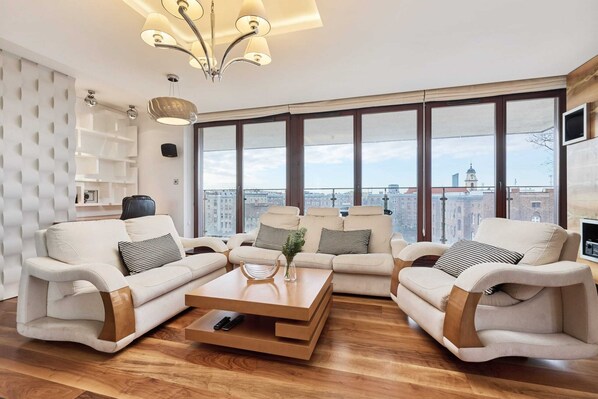 Spacious living room with elegant furniture and large windows.
